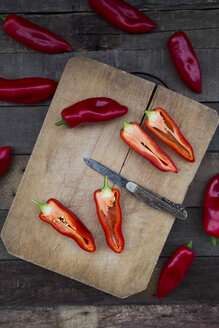 Gehackte rote Spitzpaprika auf Schneidebrett, halbiert, Taschenmesser - LVF004398