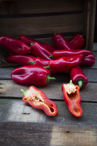 Gehackte rote Spitzpaprika, halbiert, auf Holz, lizenzfreies Stockfoto