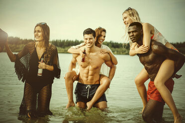 Germany, Haltern, group of five friends standing in water of Lake Silbersee having fun together - GDF000950