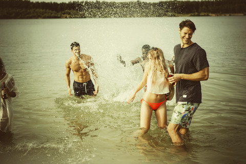 Deutschland, Haltern, Gruppe von Freunden steht im Wasser des Silbersees und hat Spaß, lizenzfreies Stockfoto