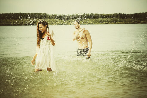 Germany, Haltern, friends standing in water of Lake Silbersee having fun - GDF000954