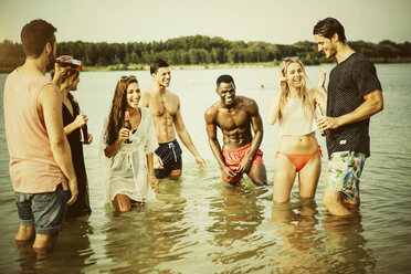 Germany, Haltern, group of seven friends standing in water of Lake Silbersee having fun together - GDF000955