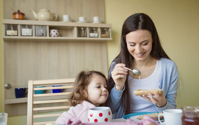 Mutter und ihre kleine Tochter zusammen am Frühstückstisch - HAPF000120