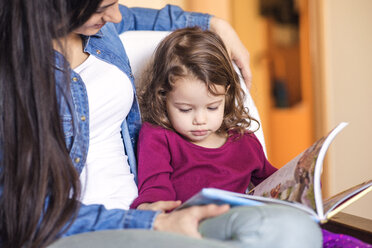 Porträt eines kleinen Mädchens, das mit seiner Mutter ein Kinderbuch anschaut - HAPF000137