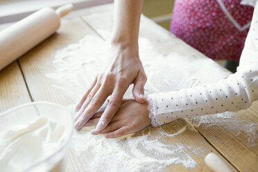 Woman's and her little daughter's hands on table top covered with flour, close-up - HAPF000138