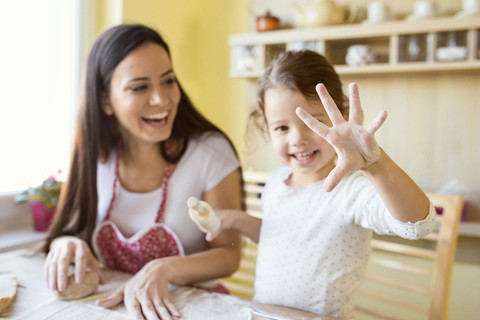 Kleines Mädchen zeigt ihre mit Mehl bestäubte Hand, lizenzfreies Stockfoto