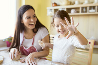 Little girl showing her hand covered with flour - HAPF000141