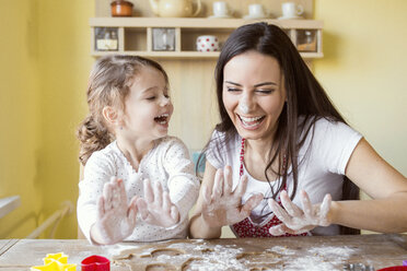 Porträt einer lachenden Mutter und ihrer kleinen Tochter beim gemeinsamen Backen - HAPF000155