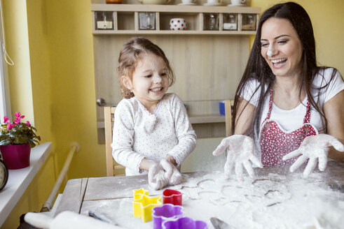 Porträt einer lachenden Mutter und ihrer kleinen Tochter beim gemeinsamen Backen - HAPF000158