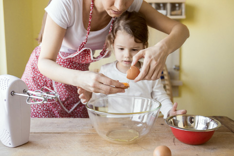 Mutter und ihre kleine Tochter backen zusammen, lizenzfreies Stockfoto