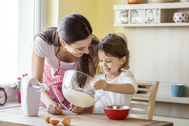 Portrait of smiling little girl and her mother baking together - HAPF000162