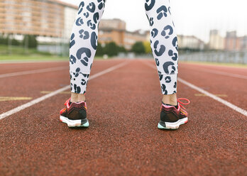 Athlete woman standing on a running track - MGOF001258