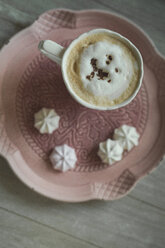 Tasse Milchkaffee mit Schokoladenraspeln und Meringues auf einem Teller - ASCF000457