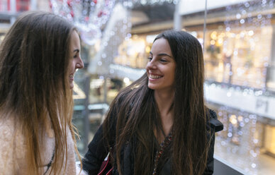 Two female friends face to face in a shopping center - MGOF001266