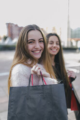Portrait of happy young woman with shopping bags - MGOF001270