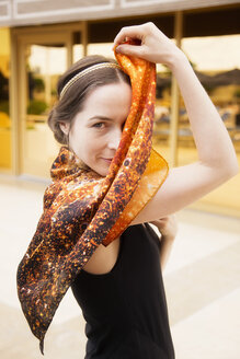 Portrait of woman holding self-created silk scarf - NDF000562