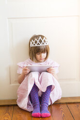 Kleines Mädchen, verkleidet als Prinzessin, schaut auf ein digitales Tablet - LVF004415
