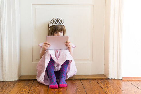 Little girl dressed up as a princess looking at digital tablet - LVF004416