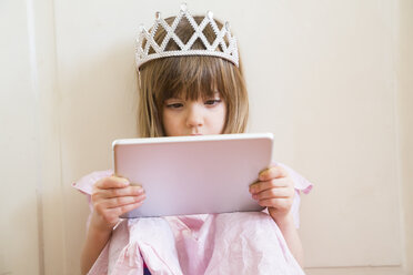 Little girl dressed up as a princess looking at digital tablet - LVF004417