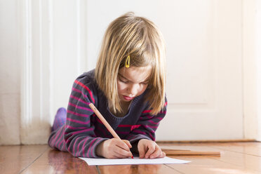 Little girl lying on the floor drawing something - LVF004420