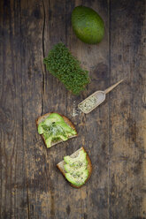 Scheibe getoastetes Brot mit Acocado, Kresse und Hanfsamen auf Holz - LVF004429