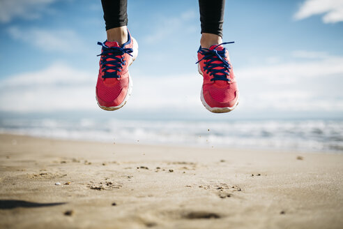 Füße einer springenden Frau am Strand - JRFF000344