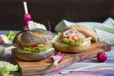 Poppy seed roll with cream cheese, lettuce leaf, salmon and onion rings garnished - YFF000512