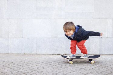 Porträt eines kleinen Jungen, der auf einem Skateboard balanciert - VABF000053
