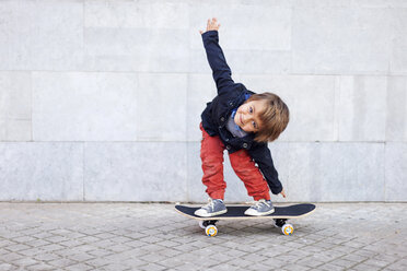 Porträt eines kleinen Jungen, der auf einem Skateboard balanciert - VABF000054