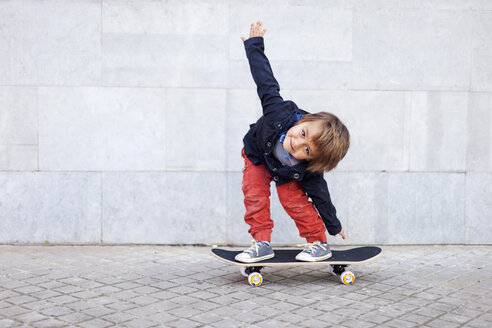 Porträt eines kleinen Jungen, der auf einem Skateboard balanciert - VABF000054