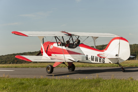 Germany, Dierdorf, Grandfather and grandson sitting on old biplane stock photo