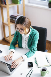 Young businesswoman working at desk in the office - AKNF000030