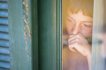 Porträt eines Jungen, der durch ein Fenster schaut - SIPF000068