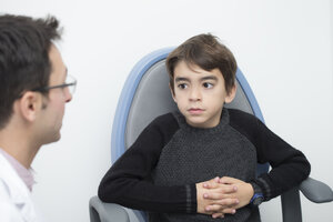 Optometrist im Gespräch mit einem Jungen auf einem Stuhl - ERLF000103