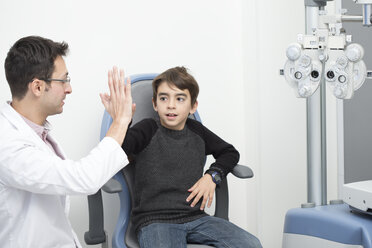 Optometrist examining eyesight of boy - ERLF000104