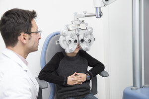Optiker untersucht die Sehkraft eines Jungen - ERLF000108