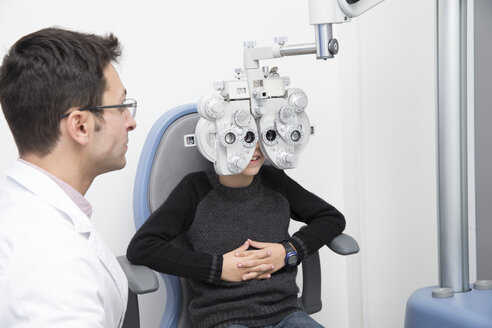 Optometrist examining eyesight of boy - ERLF000108