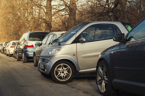 Small car parking sideways to the other cars stock photo