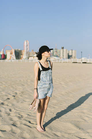 USA, New York, Coney Island, junge Frau steht am Strand, lizenzfreies Stockfoto