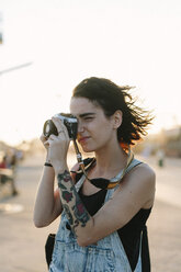 USA, New York, Coney Island, young woman taking photos at sunset - GIOF000672