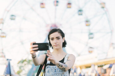 USA, New York, Coney Island, young woman taking a selfie at the amusement park - GIOF000676