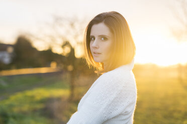 Portrait of brunette woman in field at sunrise - SHKF000456