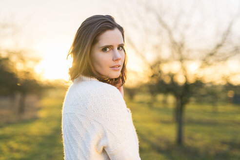 Porträt einer brünetten Frau im Feld bei Sonnenaufgang - SHKF000457