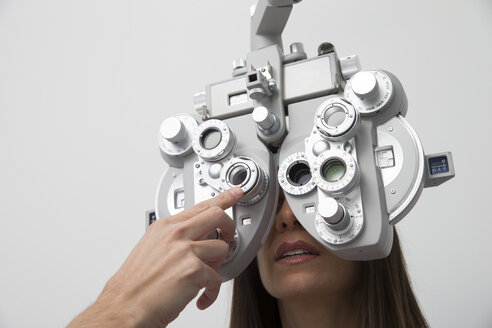 Frau beim Optiker, die einen Sehtest macht - ERLF000112