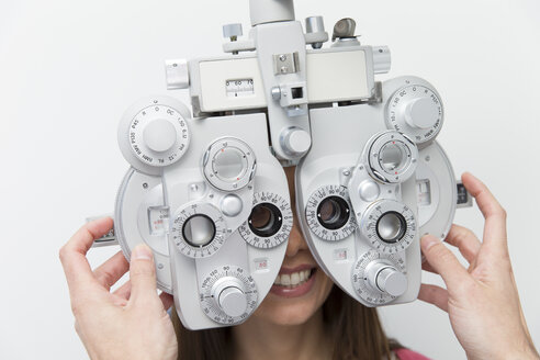 Frau beim Optiker, die einen Sehtest macht - ERLF000113