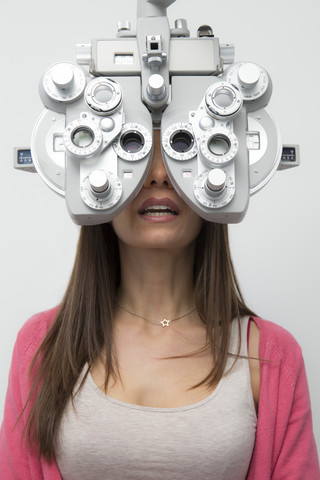 Frau beim Optiker, die einen Sehtest macht, lizenzfreies Stockfoto
