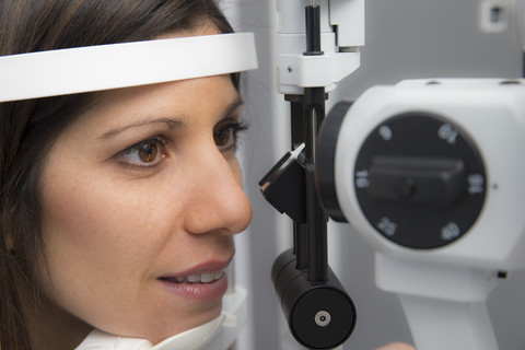 Frau beim Optiker, die einen Sehtest macht, lizenzfreies Stockfoto