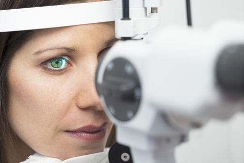 Frau beim Optiker, die einen Sehtest macht, lizenzfreies Stockfoto