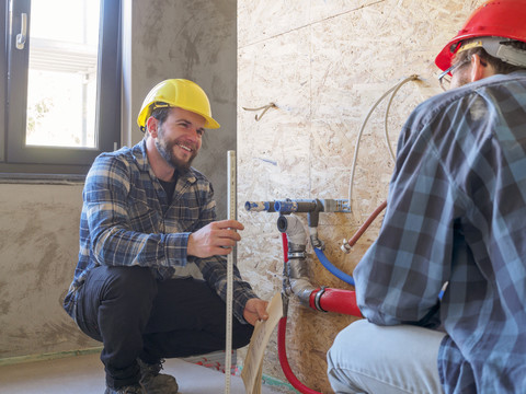 Zwei Klempner bei der Arbeit auf der Baustelle, lizenzfreies Stockfoto