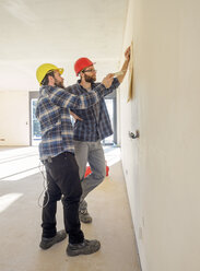 Two craftsmen discussing plan in construction site - LAF001590